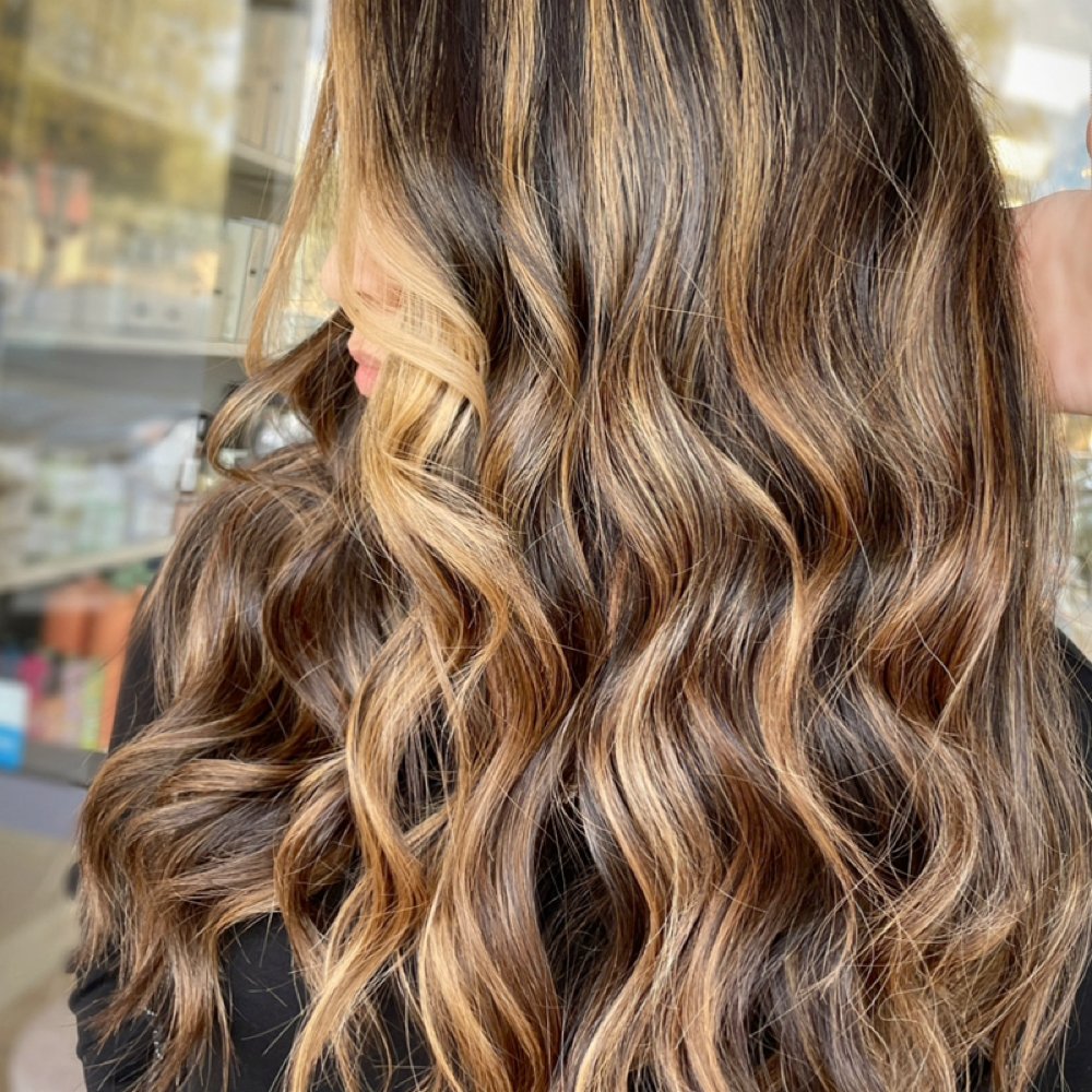 Caramel ribbons through softly waved brunette hair